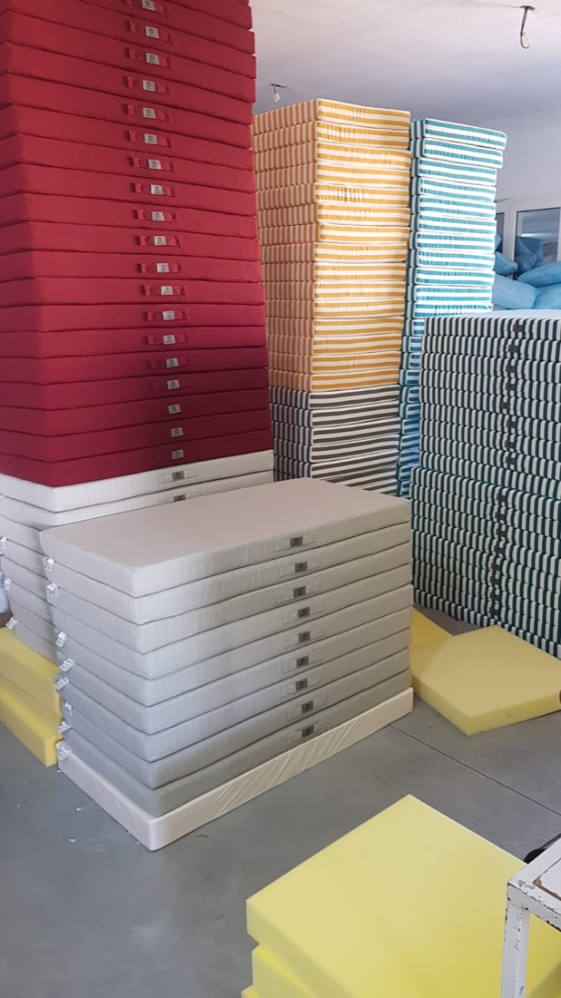 Matelas de bain de soleil empilés par coloris dans l'atelier Dinotex